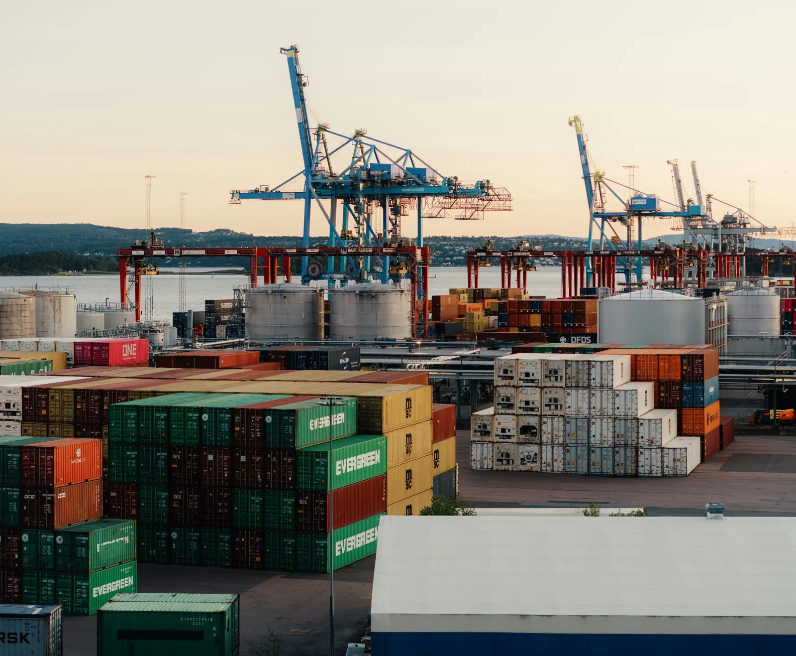 Container port with cranes at sunset